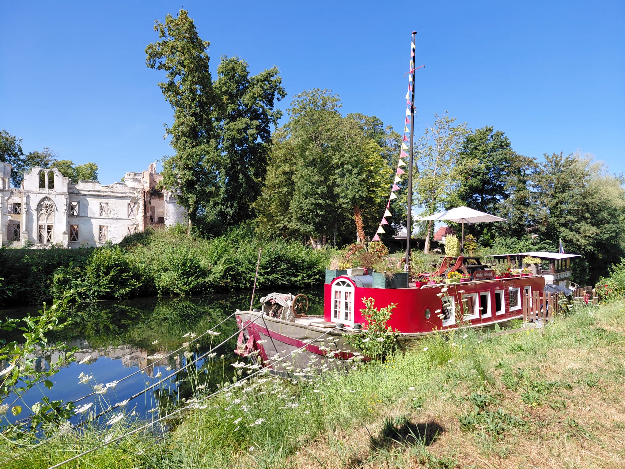 La péniche amarrée au bord d’un jardin fleuri, face au château